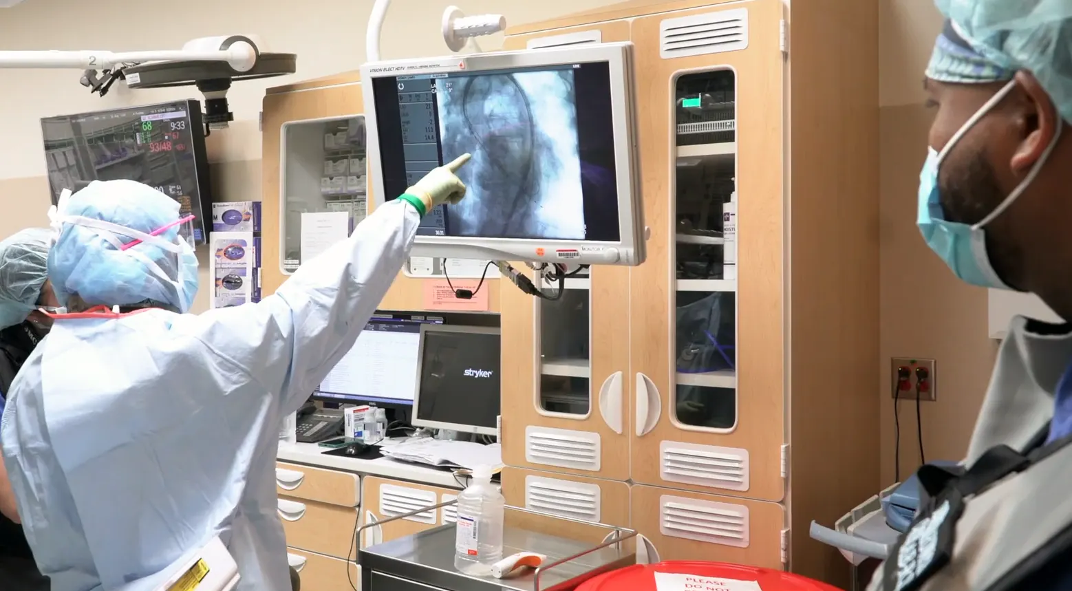 Cardiologist pointing at cardiac imagimg screen